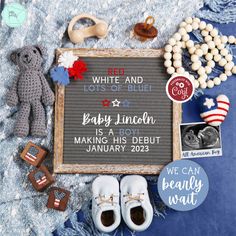 a baby announcement surrounded by toys and other items on a blue blanket with white and lots of blue