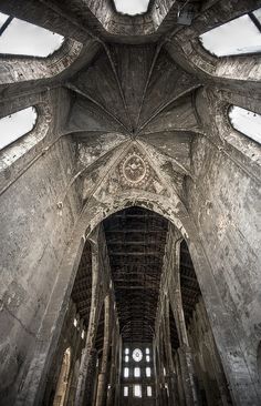 the inside of an old building with vaulted ceilings and stone pillars, looking up at the ceiling