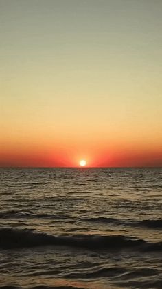 the sun is setting over the ocean with waves