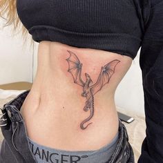 a woman with a dragon tattoo on her lower side rib - tattoos for women are very attractive