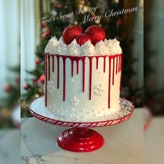 a christmas cake with white frosting and red decorations