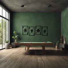 a room with a pool table, potted plant and three cards on the wall