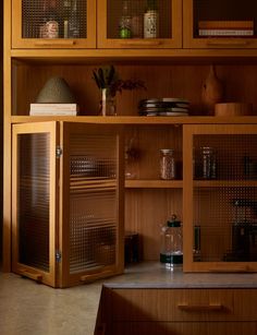 a kitchen with wooden cabinets and glass doors