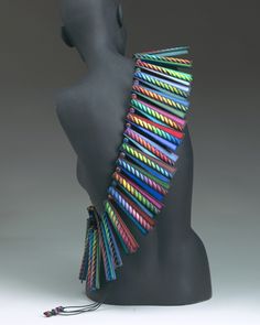 a black mannequin with multicolored strips on it's back and neck