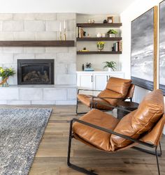 a living room with two leather chairs and a fireplace