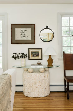 a living room with a glass table and pictures on the wall