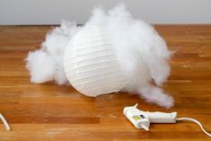 a blow dryer sitting on top of a wooden floor next to a white ball