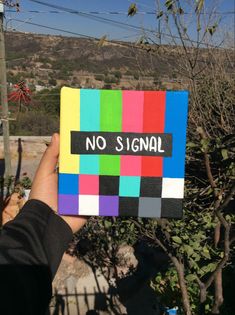 a hand holding up a colorful piece of paper with the words no signal on it