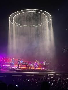 the stage is lit up with bright lights and people are standing in front of it