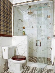 a white toilet sitting next to a walk in shower