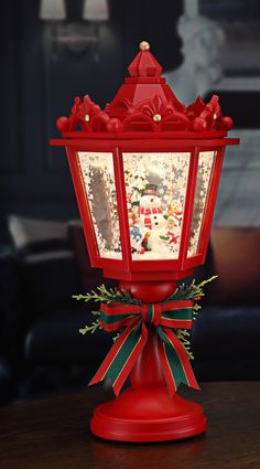 a red light with christmas decorations on the top and ribbon around it's neck