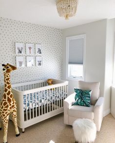 a baby's room with a giraffe stuffed animal in the crib