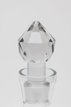 a clear glass bottle with a diamond on the top