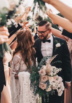 a bride and groom are surrounded by their wedding party