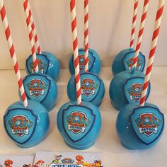 six blue candy lollipops with red and white striped straws