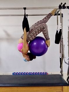 a woman doing aerial exercises on an exercise ball