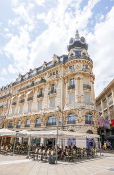 the building has many tables and chairs in front of it