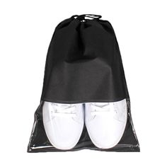 a pair of white shoes in a black drawsack bag on top of a white background