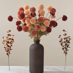 three vases with flowers in them sitting on a marble countertop next to each other