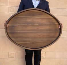 a man in a suit holding a large wooden board over his head with both hands