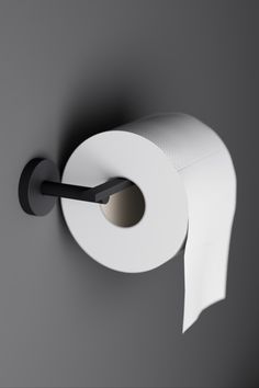 a roll of toilet paper hanging on the wall next to a black and white object