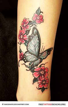 a woman's leg with a butterfly and flowers tattoo design on the side of her leg