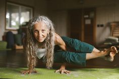 an older woman is doing yoga on the floor