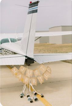 a small airplane parked on top of an airport tarmac next to a bunting banner