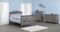 a baby's room with blue walls and white carpeting, including a gray crib