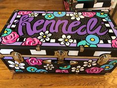 an old suitcase with flowers and the word rencel painted on it sitting on a wooden floor