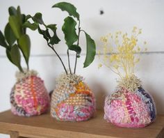 three vases with plants in them sitting on a shelf