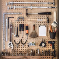 a pegboard with many tools hanging on it