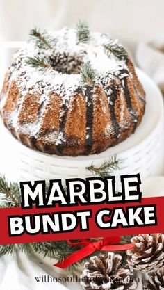 marble bundt cake with pine cones and red ribbon on white platter next to it