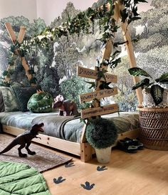 a bed room with a wooden floor and a wallpapered forest scene on the wall