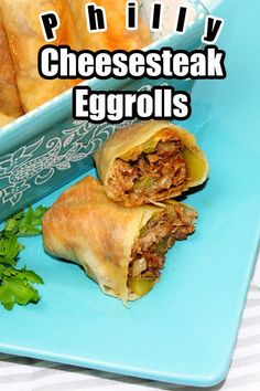 some food is laying out on a blue plate with the words phily cheesesteak eggrolls