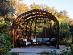 an outdoor living area with couches, tables and trelliss on the patio