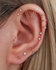 an ear with several different piercings attached to the middle of it, and two smaller ones