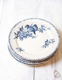 a stack of blue and white plates sitting on top of a wooden table next to each other