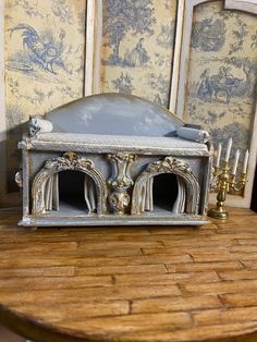 a miniature bed sitting on top of a wooden table