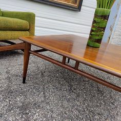 a wooden table sitting next to a green chair