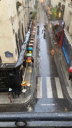 an overhead view of a city street with people walking on the sidewalk in the rain