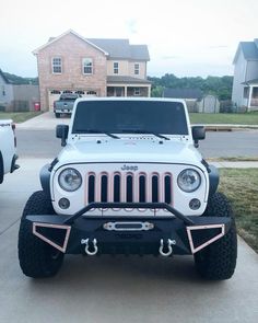 a white jeep parked in front of a house