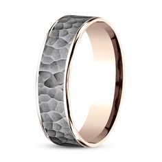 a men's wedding band with an intricate design in rose gold and grey stone