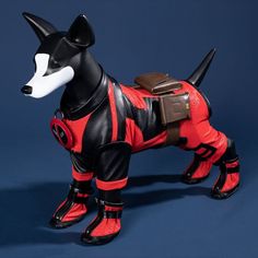 a black and white dog wearing red boots on a blue background with a brown bag