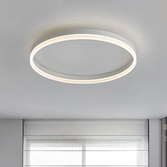 a modern circular light fixture in a white room