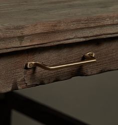 an old wooden table with brass handles and a metal handle on the top, against a dark background