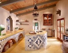 a large kitchen with blue and white tiles on the counter