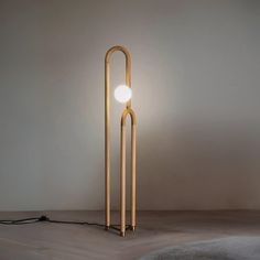 the floor lamp is made out of wood and has a round light bulb on it