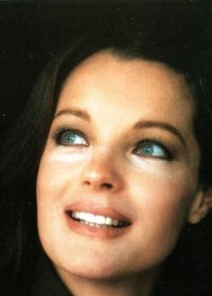 a woman with blue eyes is smiling for the camera