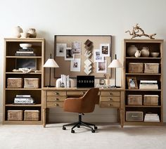 a chair and desk in front of a bookcase with pictures on the wall behind it